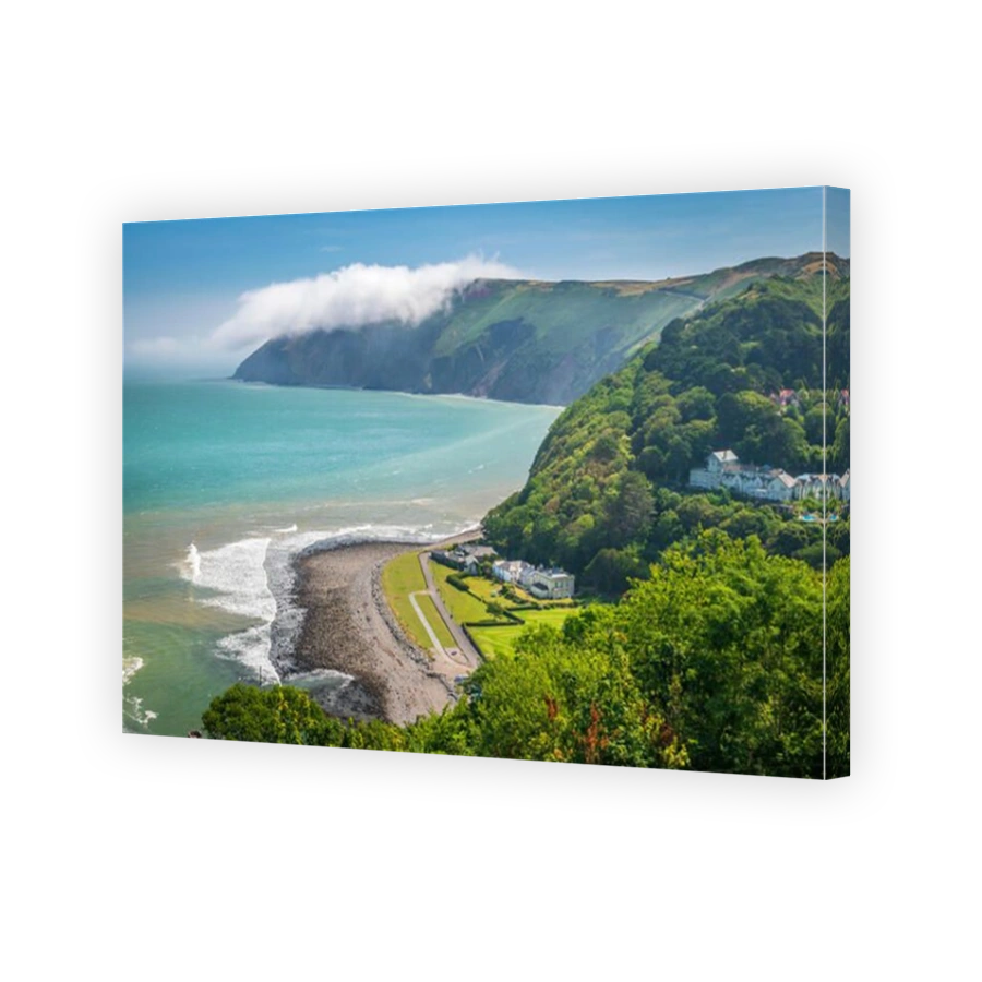 In the distance the mist rolls off Foreland Point, as the picturesque little bay at Lynmouth in Devon is bathed in early morning summer sunshine.