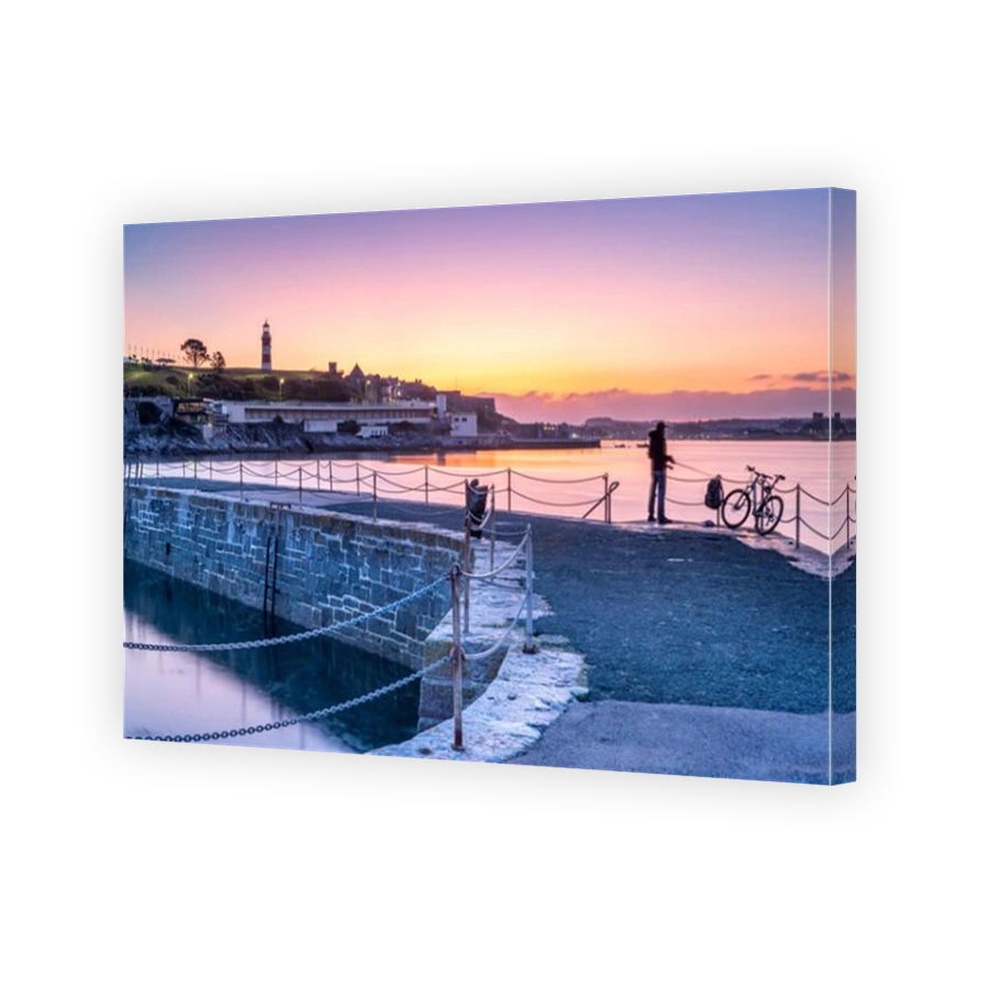 Plymouth, Devon, England. Wednesday 18th September 2019. UK Weather. After a cold night, in the first light of dawn an angler waits for a bite as the sky glows pink over Smeatons Tower on The Hoe and the harbour in Plymouth, Devon, South West England . Credit: Terry Mathews/Alamy Live News