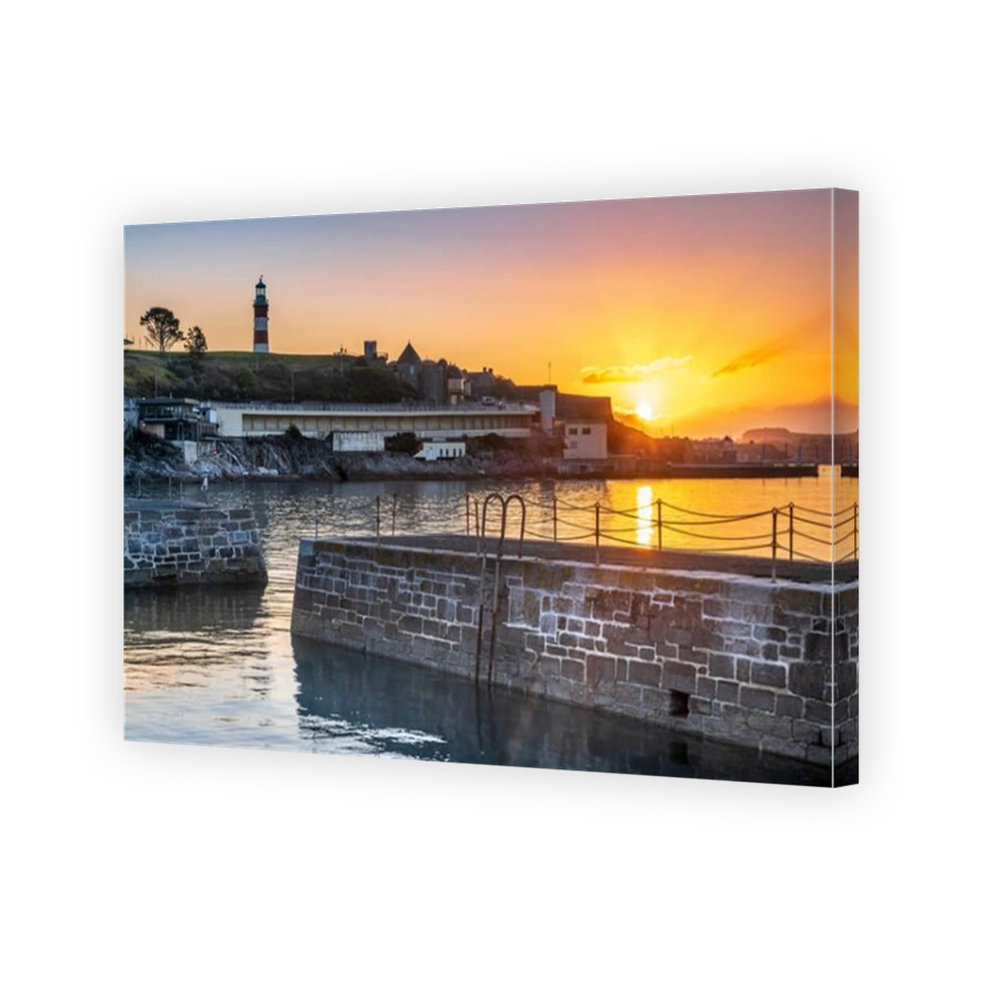 Plymouth, Devon, England. Wednesday 18th September 2019. UK Weather. After a cold night, the first rays of sunshine break through the clouds as the sky glows pink over Smeatons Tower on The Hoe and the harbour in Plymouth, Devon, South West England . Credit: Terry Mathews/Alamy Live News