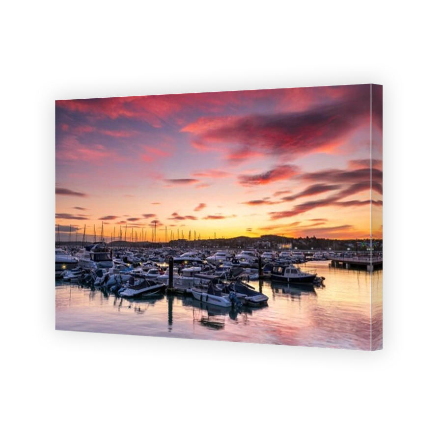 Torquay, South Devon, England. After a day of sunshine and showers on the south coast, as the sun sets a colourful sky lights up the calm waters of th