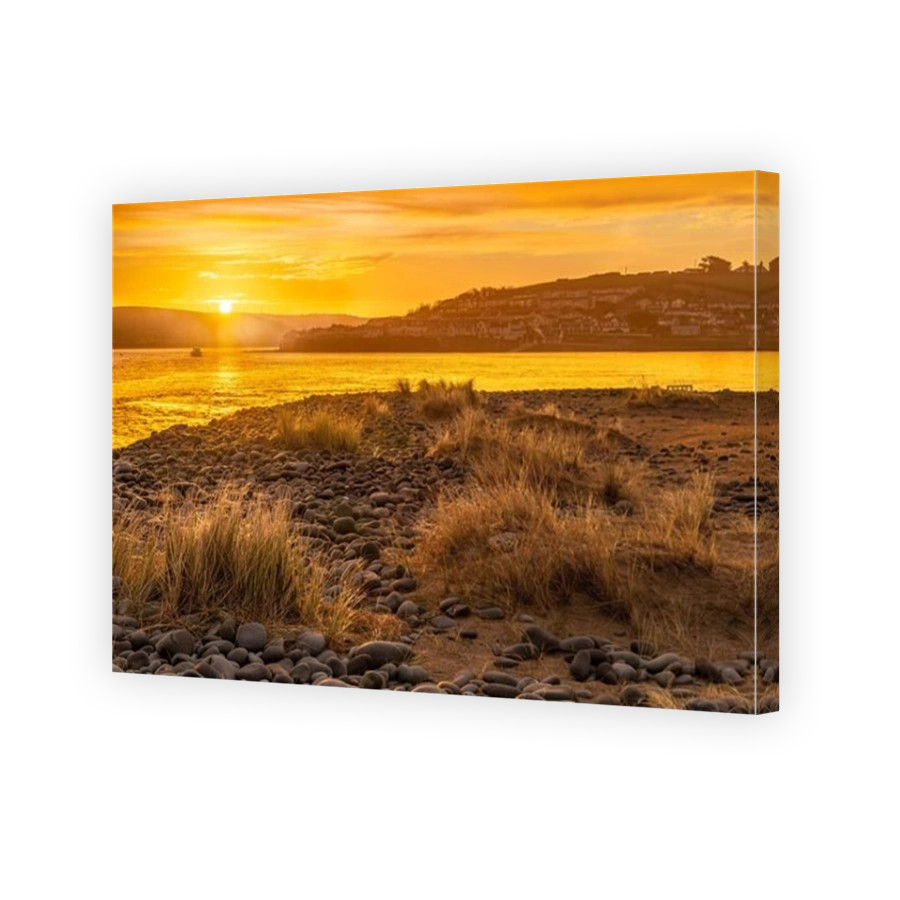 Northam Burrows near Appledore, North Devon, England. As the sun rises behind the coastal villages of Appledore and Instow, the  mudflats on the River
