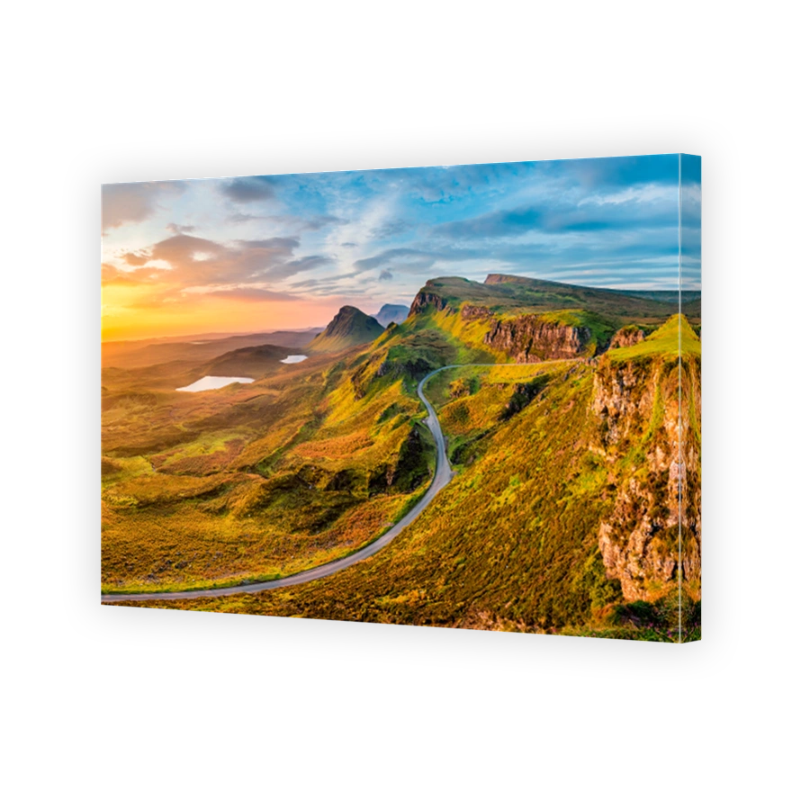 Long winding road at Quiraing on the Isle of Skye with a beautiful vibrant sunrise sky.