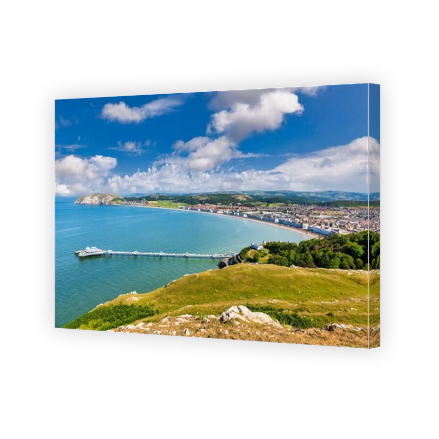 Llandudno, the pier and the Little Orme, from the Great Orme in summer. Popular seaside resort, the UK's second most popular, was built in the 19th ce