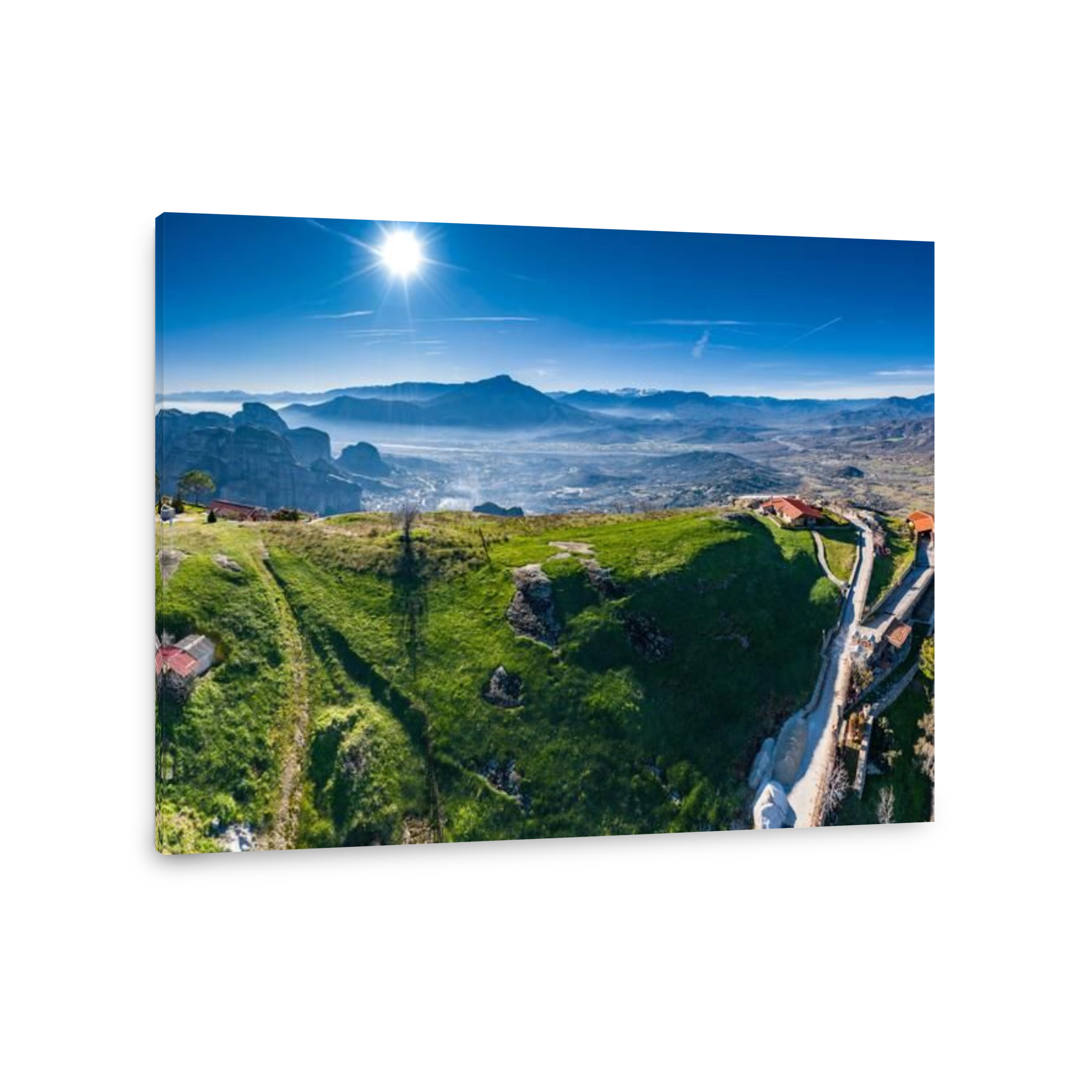 Aerial view of monastery of landmark canyon of Meteora and breathtaking picturesque valley at sunset, shadows, twisted road, green lawn