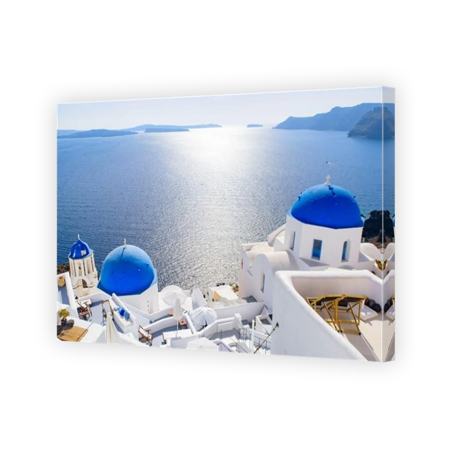 Blue domed church and traditional white houses facing Aegean Sea in Oia, Santorini, Greece