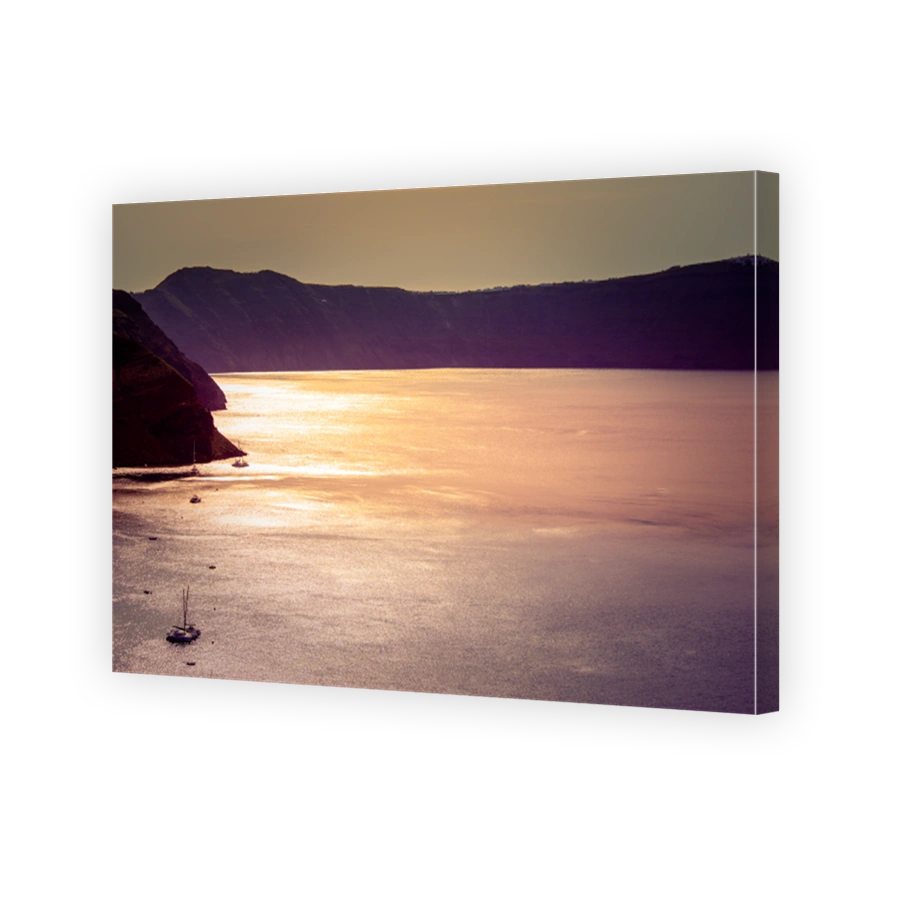 Sailing boats in the vastness of aegean sea at golden hour, Santorini, Greece.