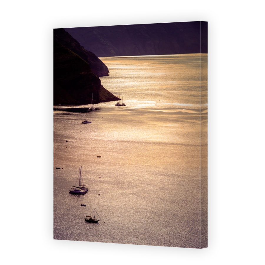 Sailing boats in the vastness of aegean sea at golden hour, Santorini, Greece.