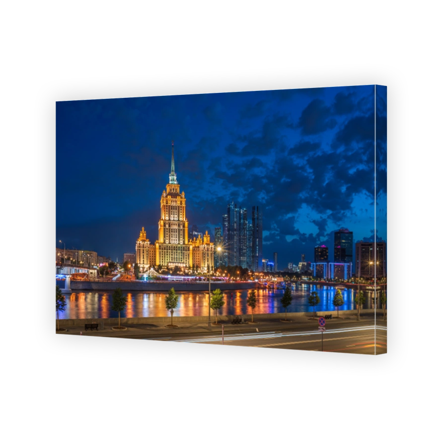 Illuminated high-rise stalinist building near river at summer night in Moscow, Russia. Historic name is Hotel Ukraina.