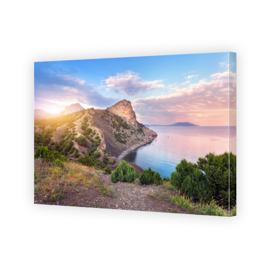 Summer landscape at sunset. Green trees against the sea, mountains and blue sky with clouds and sunlight. Travel and nature background. Colorful evening landscape. Vacations. Park in crimean mountains