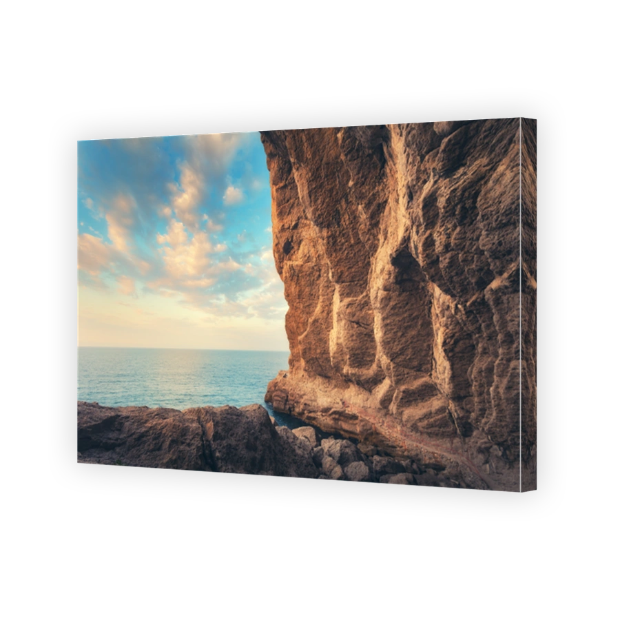 Path leading through the grot at sunset in Crimea. Beautiful landscape with cave, stones, rocks, trail, sea and blue sky with clouds in the evening. Travel and adventure in summer. Vintage style