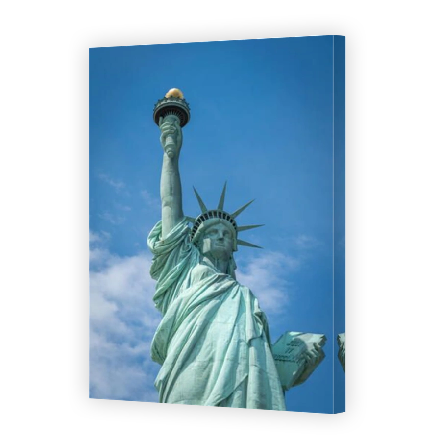 Shot of the Statue of Liberty in New York City, Usa. The shot is taken during a beautiful sunny day with a blue sky and white clouds in the background