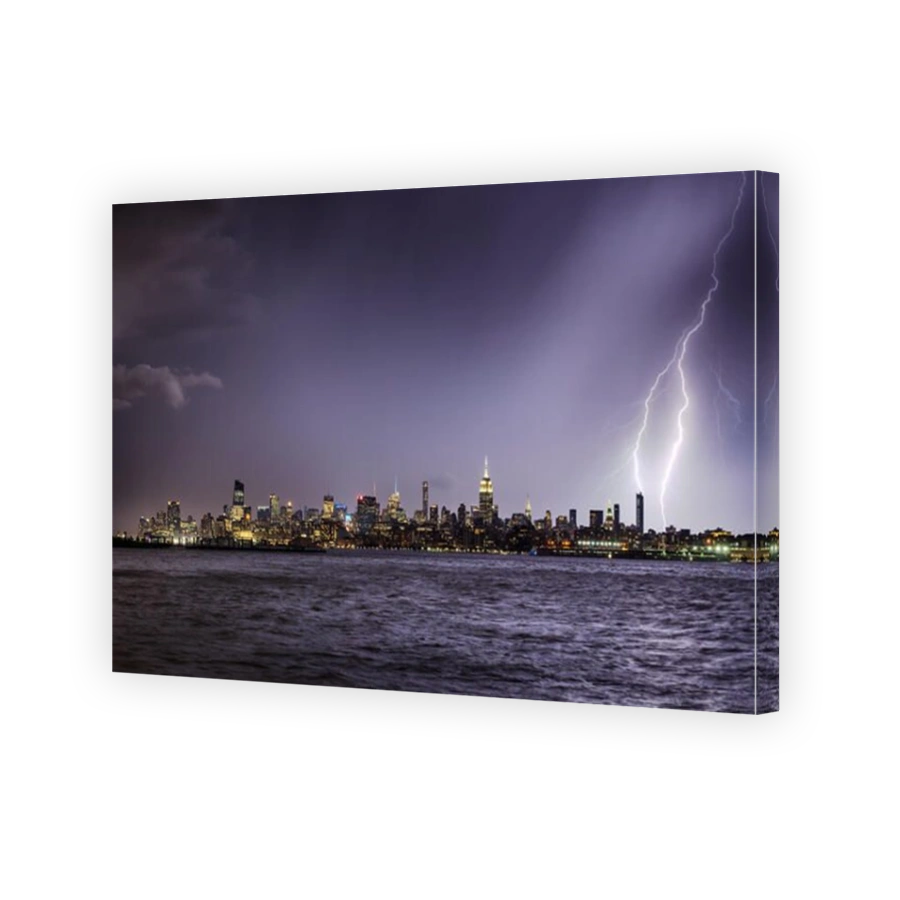 Lightning hitting a New York City skyscraper at twilight. Stormy skies over Midtown West Manhattan from the Hudson River