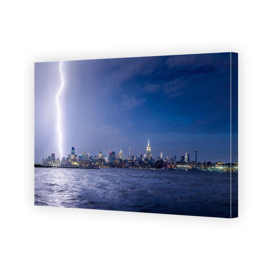 Lightning striking Midtown New York City skyscrapers at night. Stormy skies over Manhattan from the Hudson River