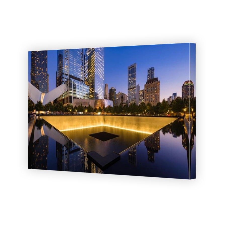 The North Reflecting Pool illuminated at twilight with view of the World Trade Center Tower 3 and 4 and the Oculus. Lower Manhattan, New York City