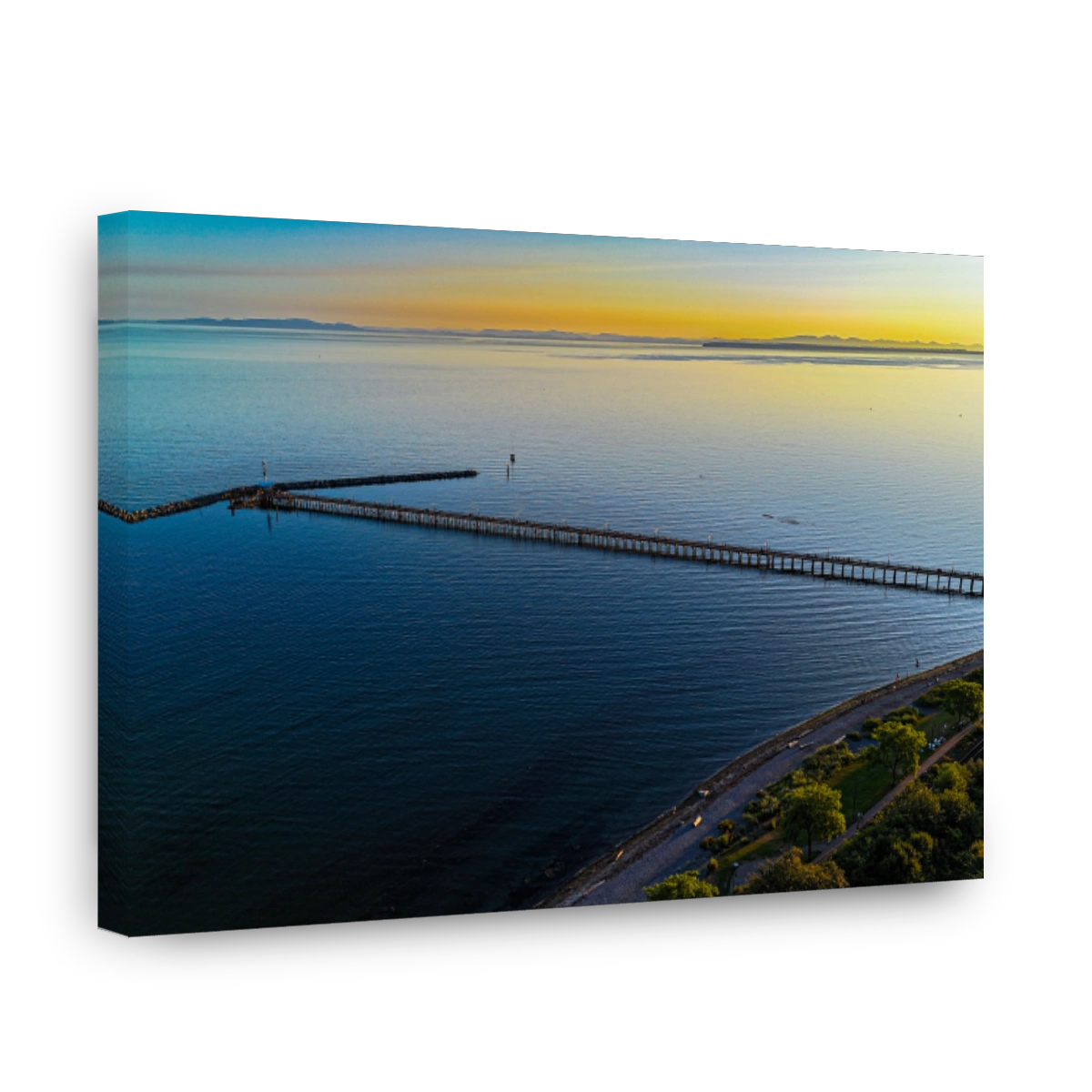 Serene drone view of White Rock Pier extending into calm waters during a stunning sunset in Canada