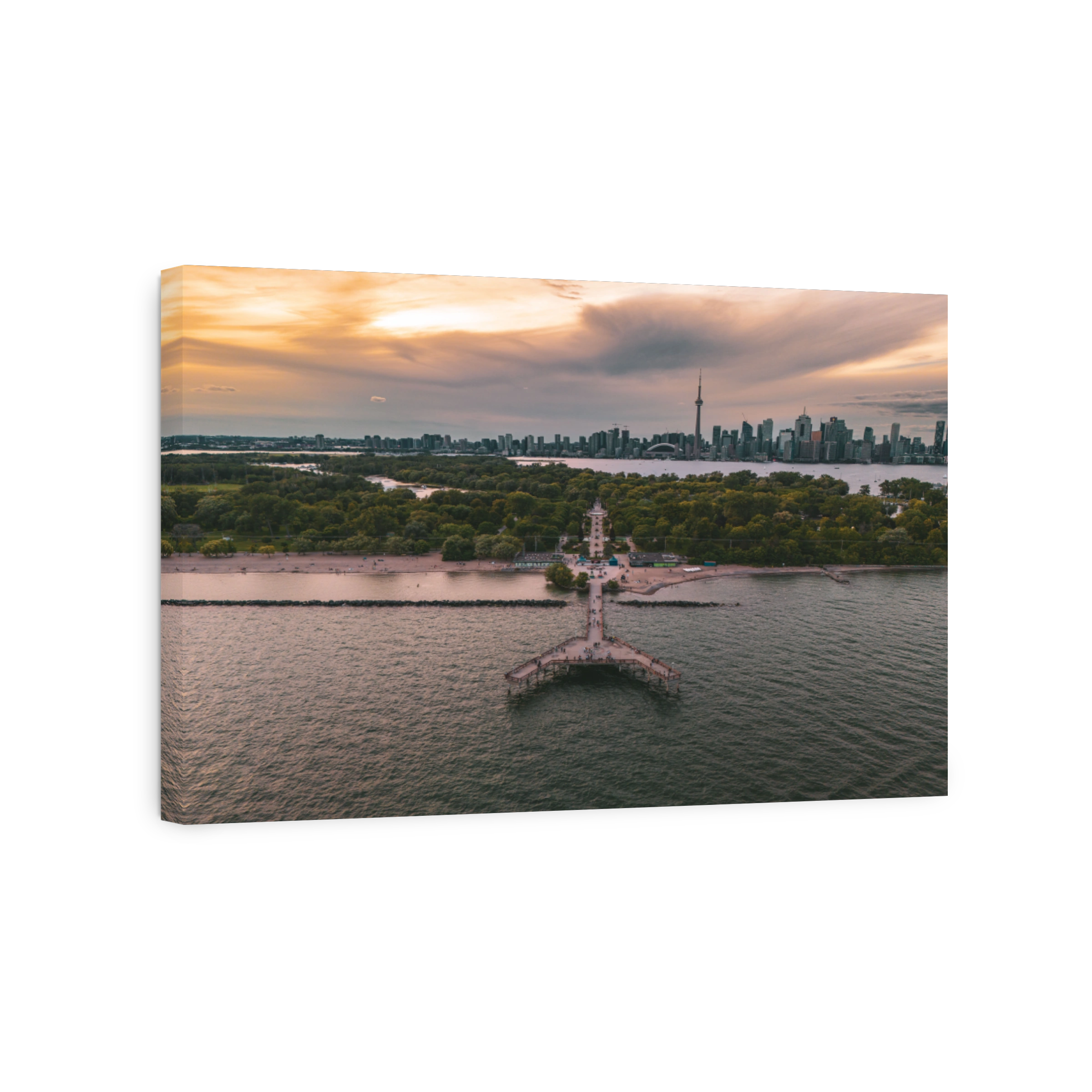 Toronto skyline at sunset with pier and greenery.