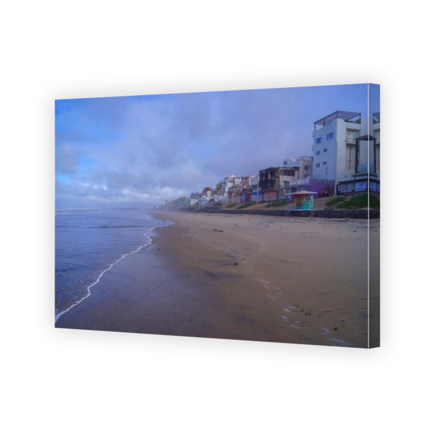A serene view of Playas de Tijuana beach, showcasing the tranquil Pacific Ocean and colorful buildings along the shore in Mexico.