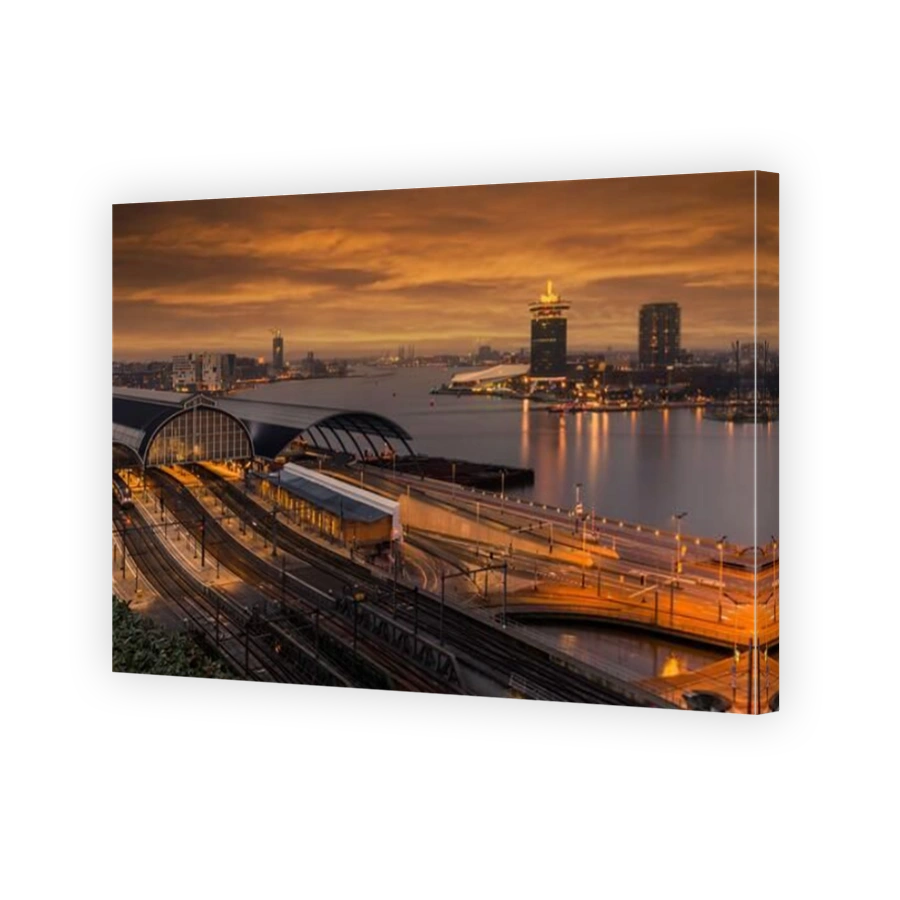 View of the Amsterdam train station and the Amstel river at night, Netherlands