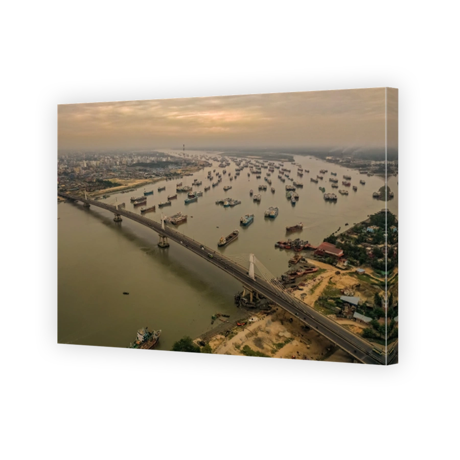 Numerous ships in the river and a long bridge over the river