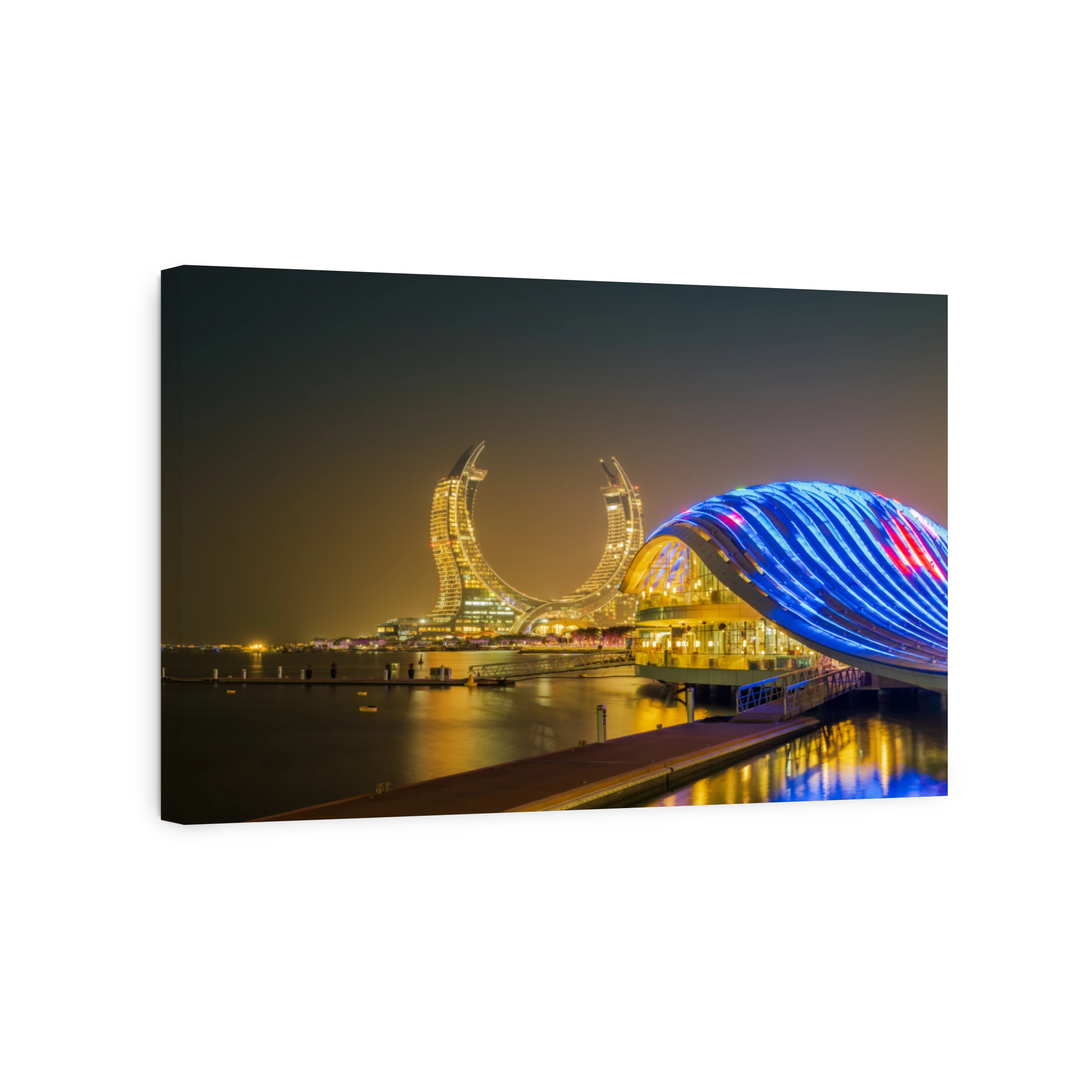 New modern buildings on the beachfront lit up at night in Lusail, Doha, Qatar