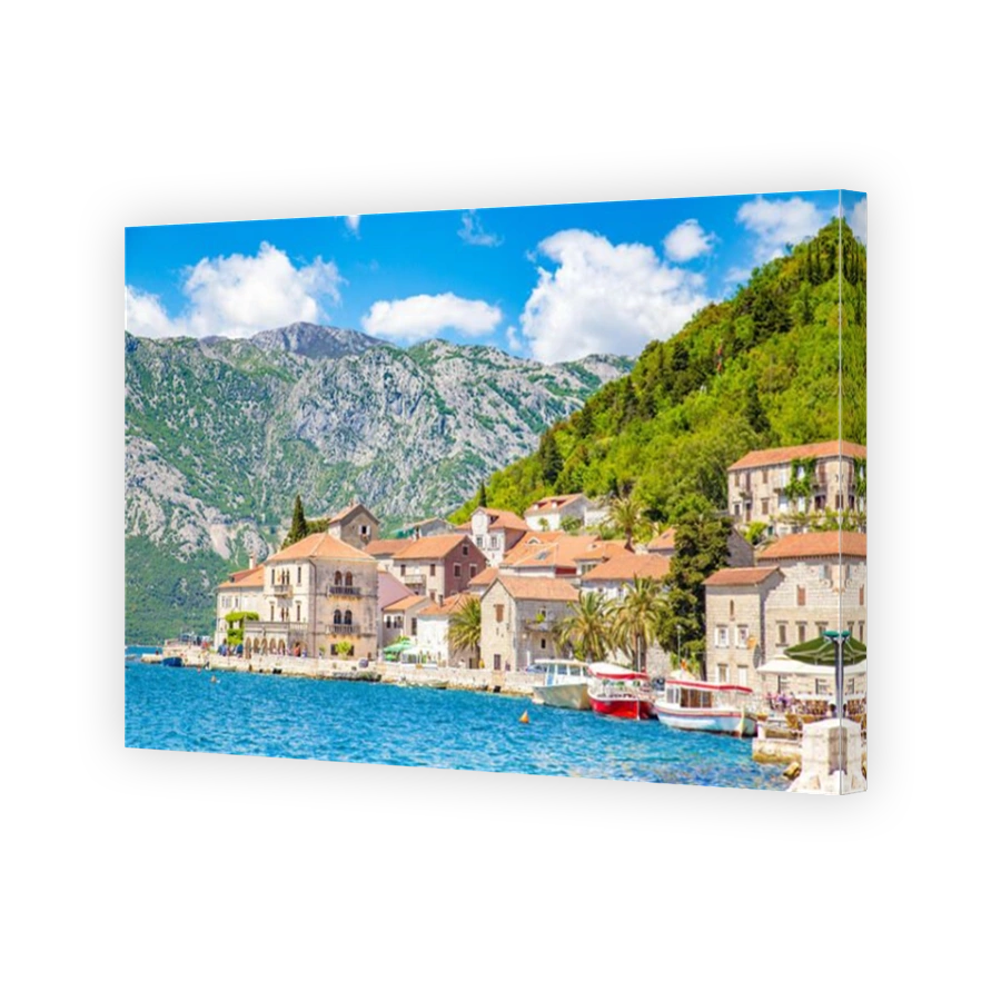 Scenic panorama view of the historic town of Perast at famous Bay of Kotor on a beautiful sunny day with blue sky and clouds in summer, Montenegro