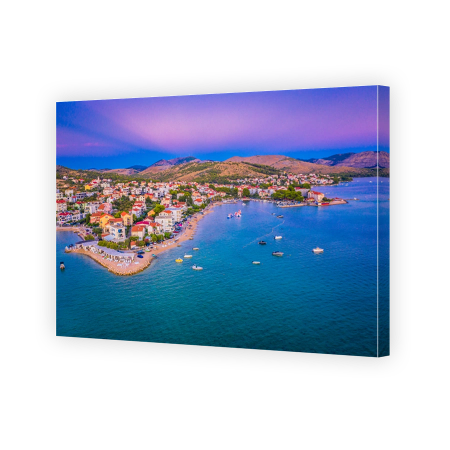 Aerial evening view of coastal village with lights along Adriatic Sea