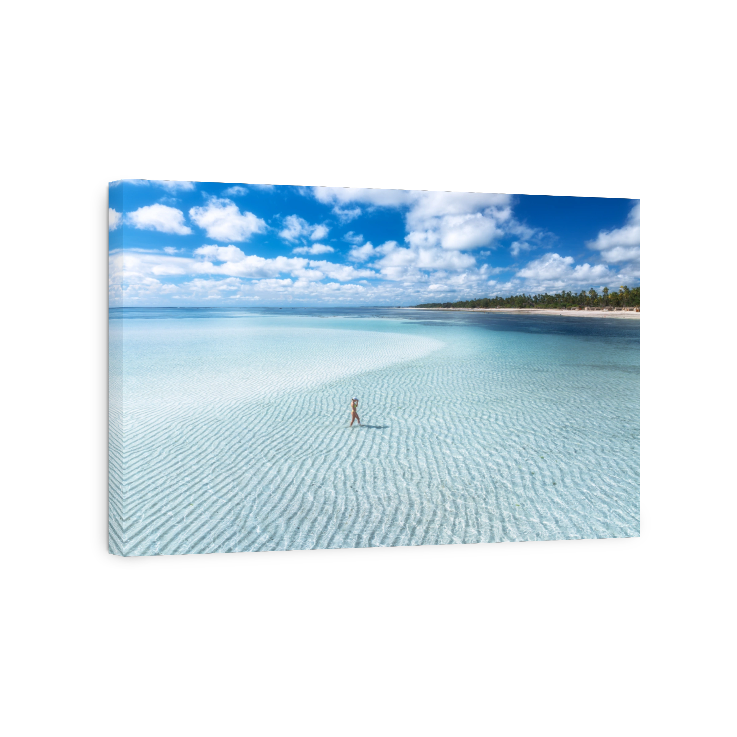 Aerial view of alone young woman on the sandbank in ocean, white sand, blue sea during low tide at sunny summer day in Zanzibar island. Top view of girl, sand spit, bay, clear water, sky with clouds
