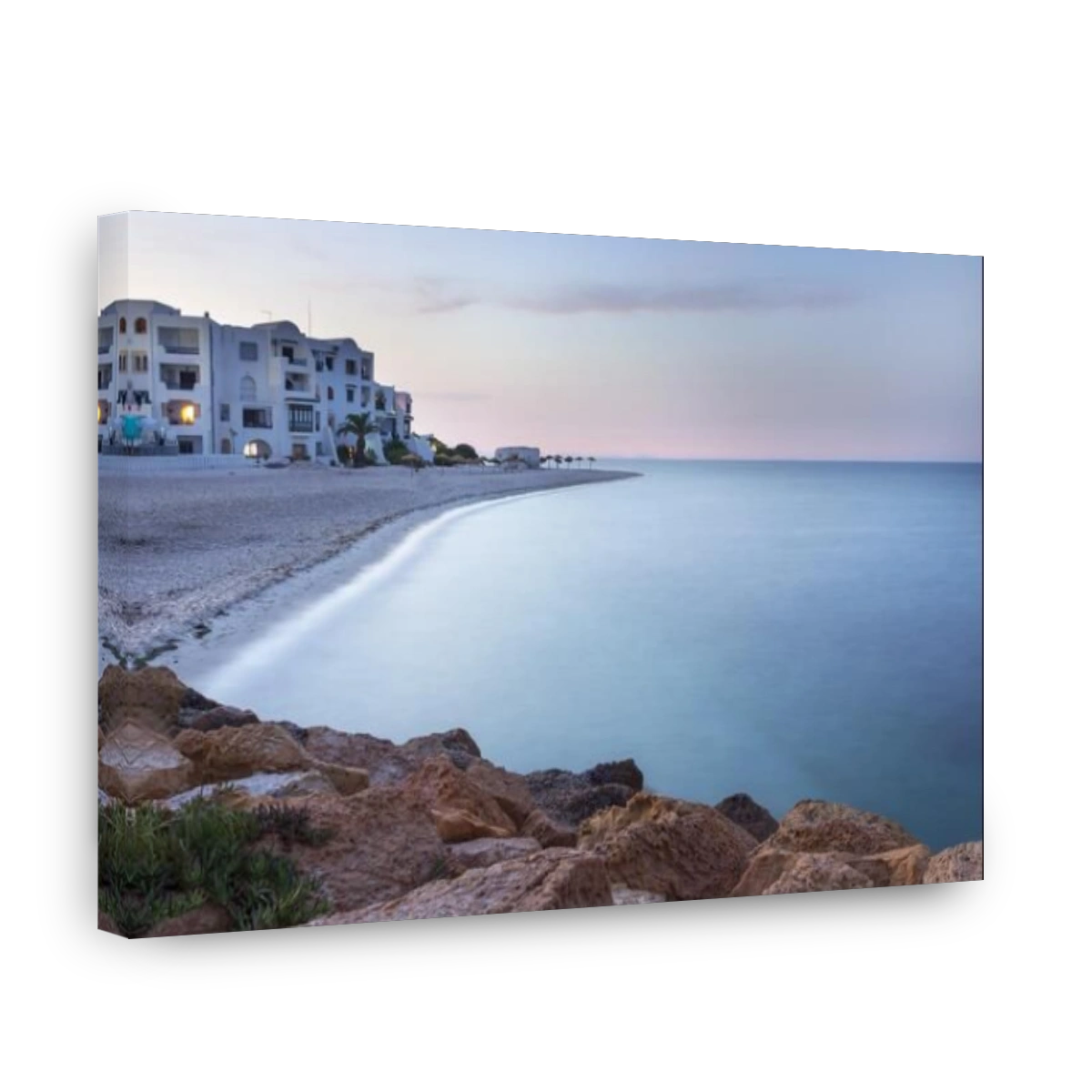Long exposure Mediterranean sea, beach with white rocks, white hotel and foreground rocks in Marina, Port El Kantoui, Tunisia, during blue hour