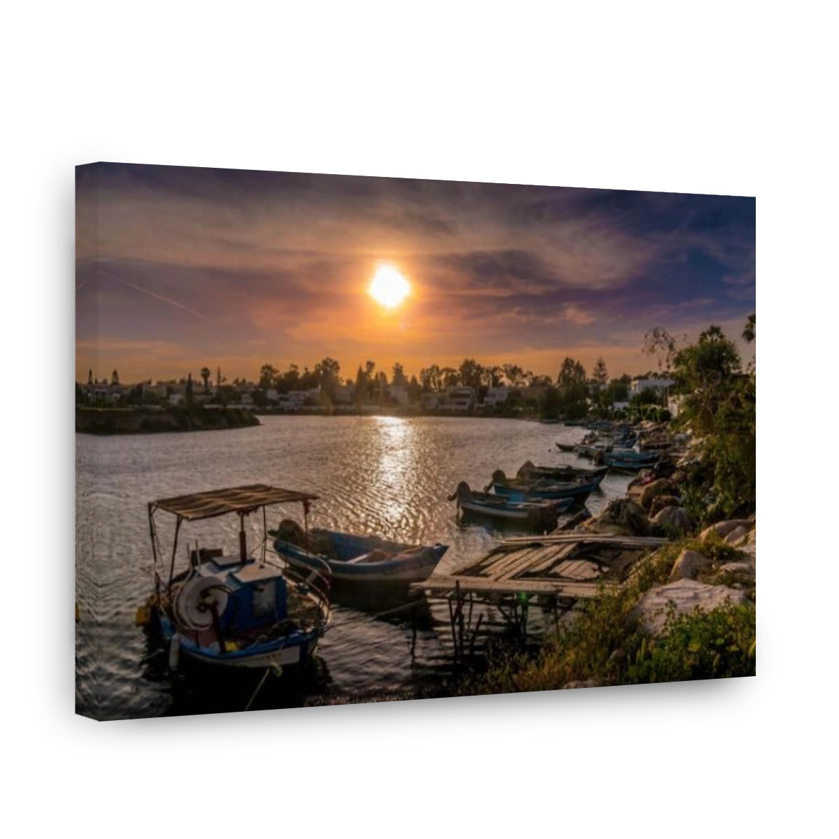 The beautiful scenic sunset in the Carthage bay in Tunisia's waterfront in Tunis with fishing small boats in the water and pinky clouds.