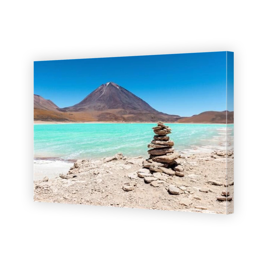 Panorama of a wish stone pyramid by the Laguna Verde (green lagoon) and the Licancabur volcano, Bolivia.