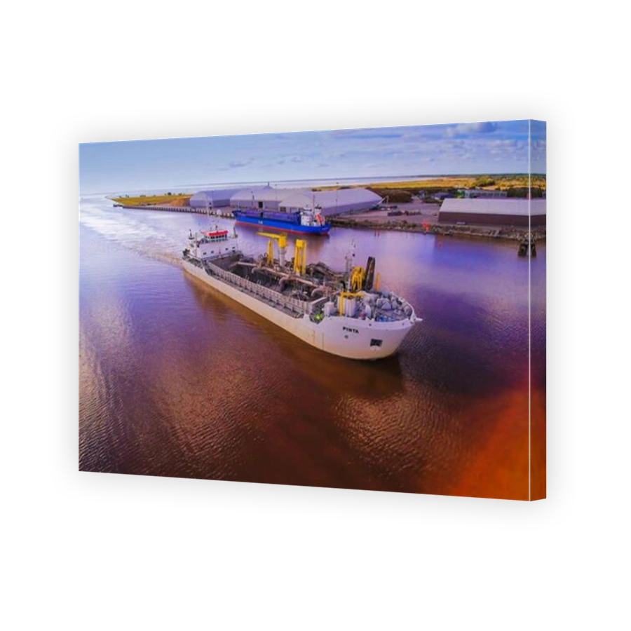 Along the industrial coast in Parnu Estonia where a big ship is travelling on the sea with heavy tools