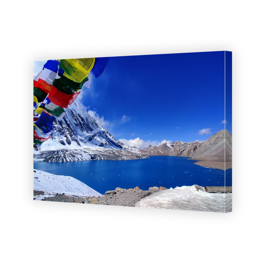The breathtaking Tilicho Lake, framed by colourful prayer flags, sits peacefully amidst the snow-covered peaks of the Annapurna range.