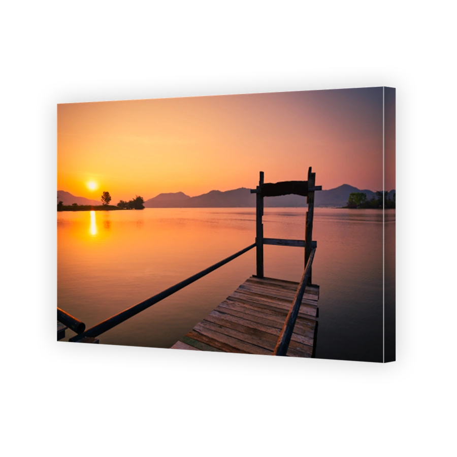 Sunrise over mountain and lake with wooden pier