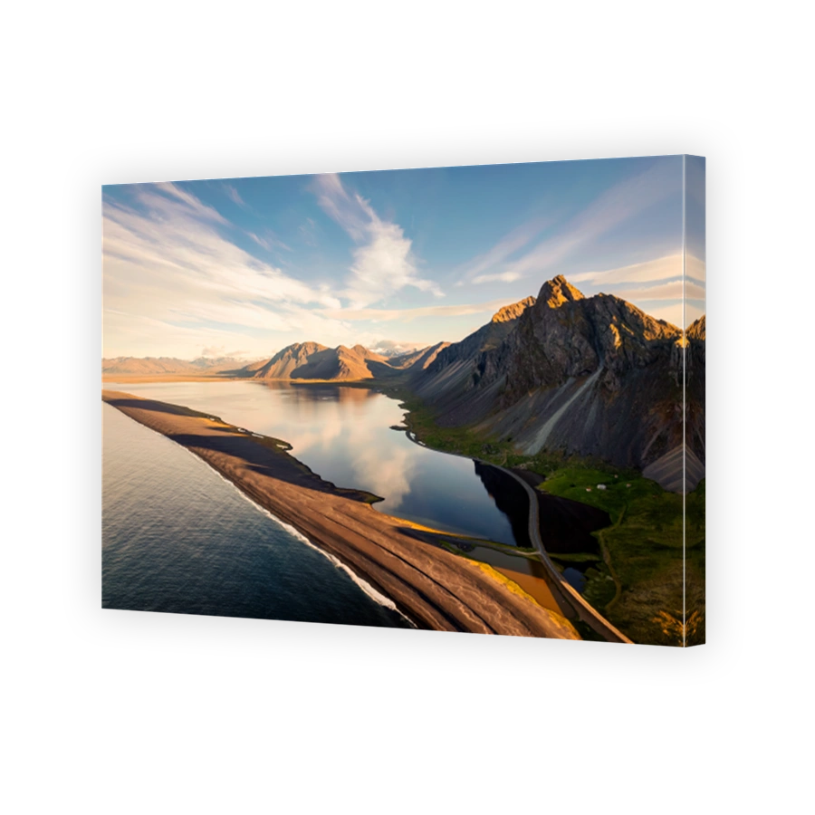Beautiful sunrise over volcanic mountain range in rural scene by the ocean of peninsula at summer in Iceland