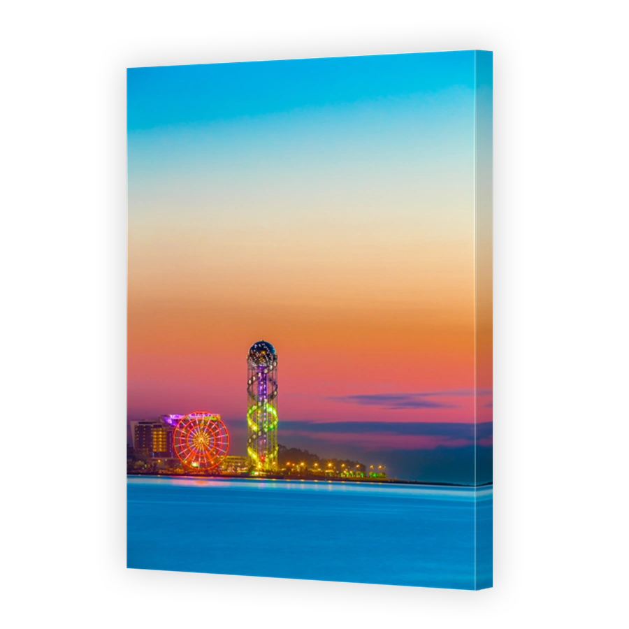 Batumi, Adjara, Georgia. Sunset Or Sunrise. Bright Evening Sky In Yellow, Orange And Purple Colors. View From Sea Beach To Illuminated Cityscape With Modern Urban Architecture, Skyscrapers And Tower.