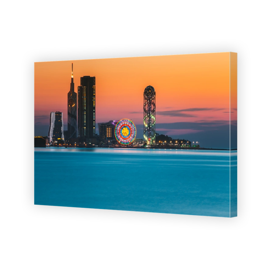 Batumi, Adjara, Georgia. Skyline Of Resort Town At Sunset Sunrise. Bright Orange Evening Sky. View From Sea To Illuminated Cityscape With Modern Urban Architecture, Skyscrapers And Tower. Golden Hour