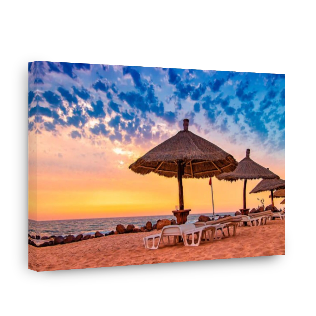 Deck chairs with umrellas on the beach with beautiful sunset in Senegal, Africa. There is blue sky and golden and red sun. It is tropical paradise wit