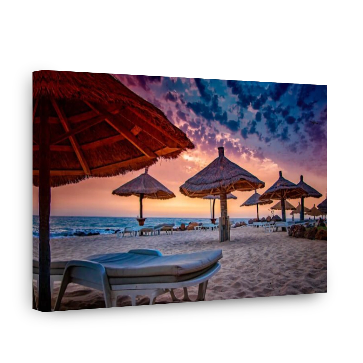 Deck chairs with umrellas on the beach with beautiful sunset in Senegal, Africa. There is blue sky and golden and red sun. It is tropical paradise wit
