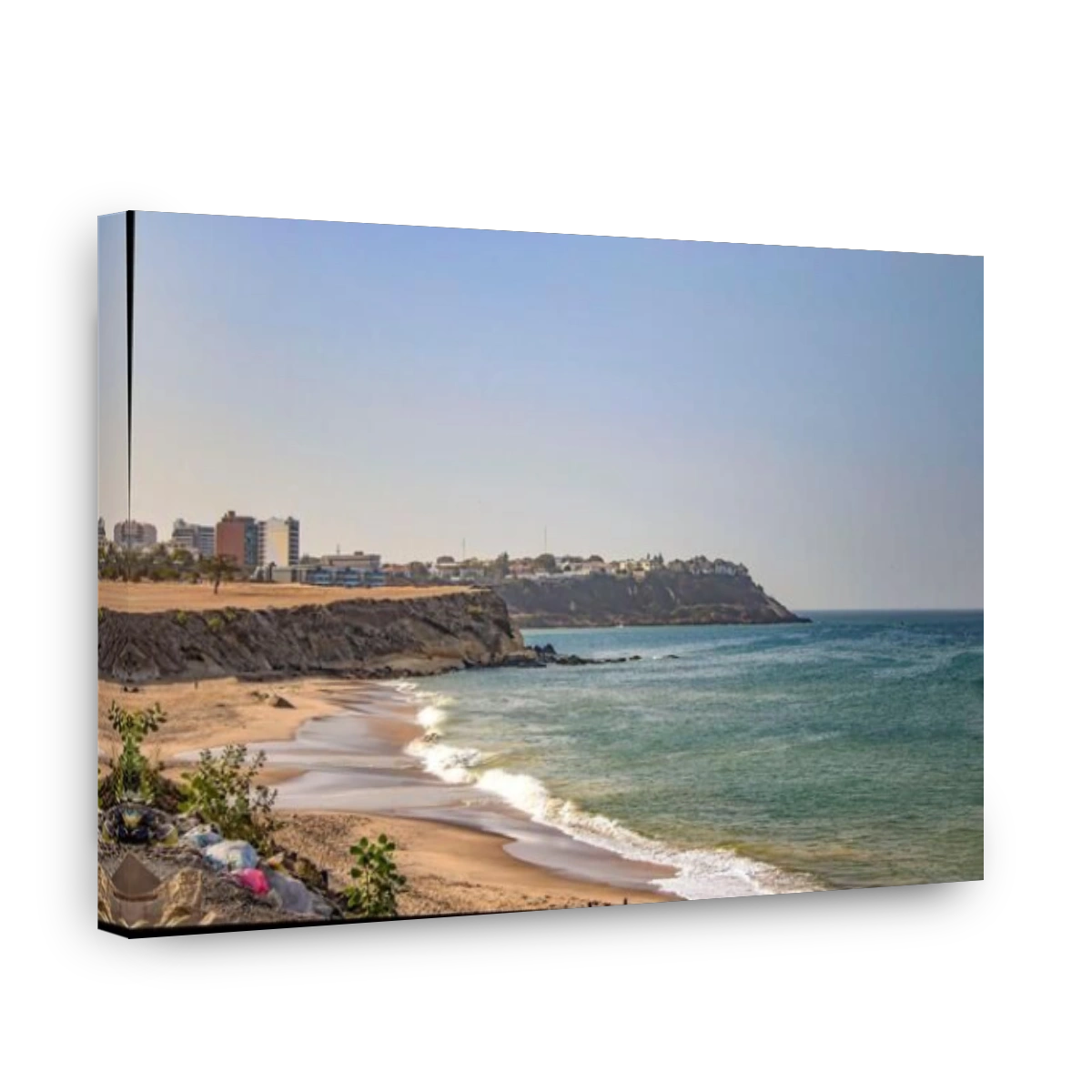 Views of the coastline of Dakar, Senegal, Africa. It is a beautiful long beach and in the background you can see buildings and palm trees and a