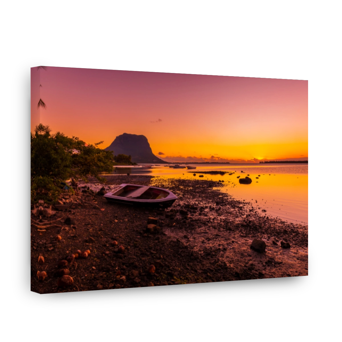 Boats and a low tide ocean at bright sunset with Le Morn mountain in Mauritius.