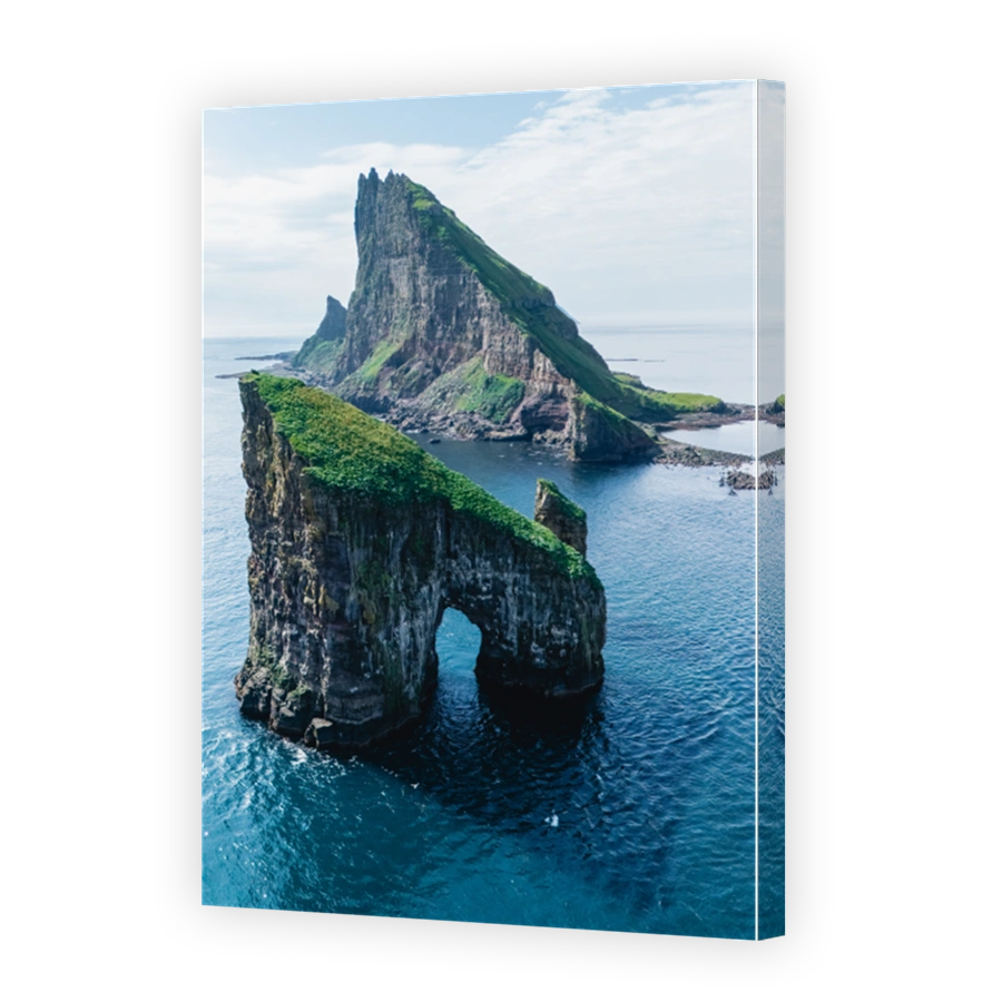 Majestic cliffs and sea stacks of the Faroe Islands with lush greenery under a clear sky
