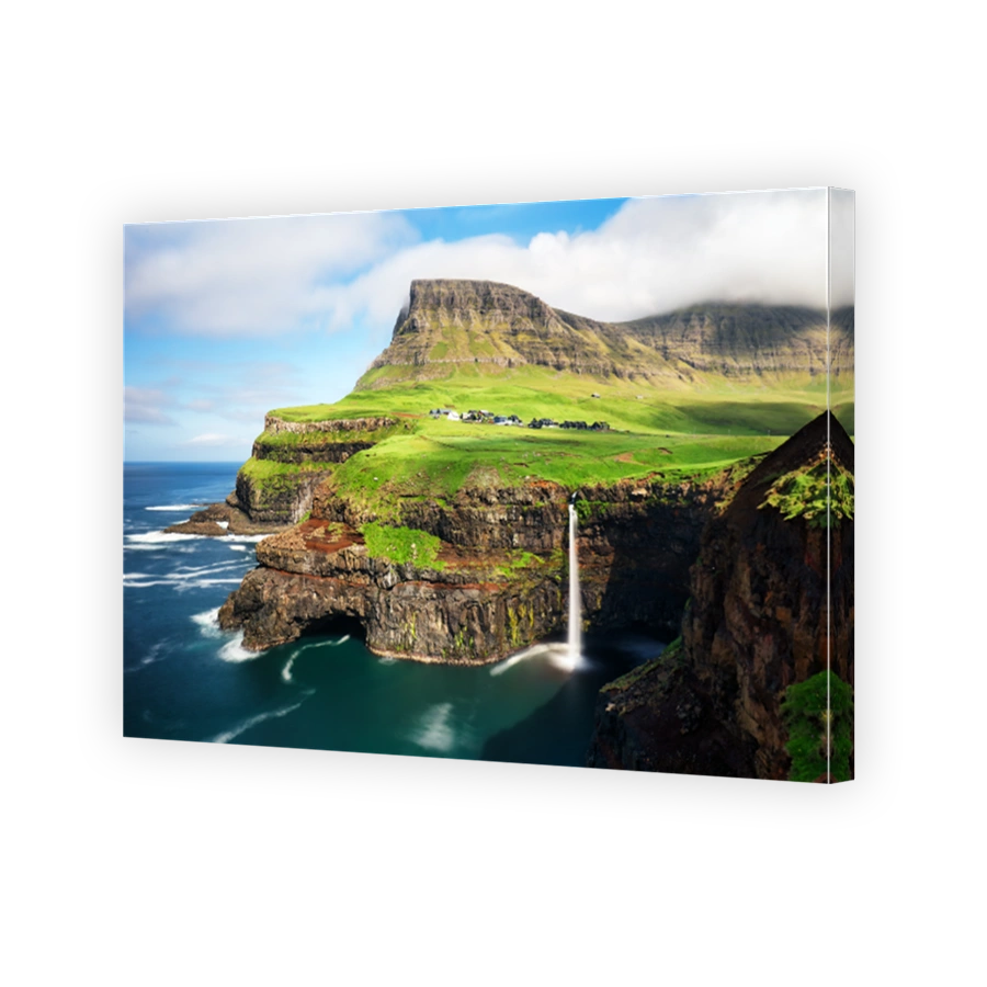 Faroe Islands waterfall Múlafossur near village Gasadalurron the Island Vágar. Green mountain caost landscape.