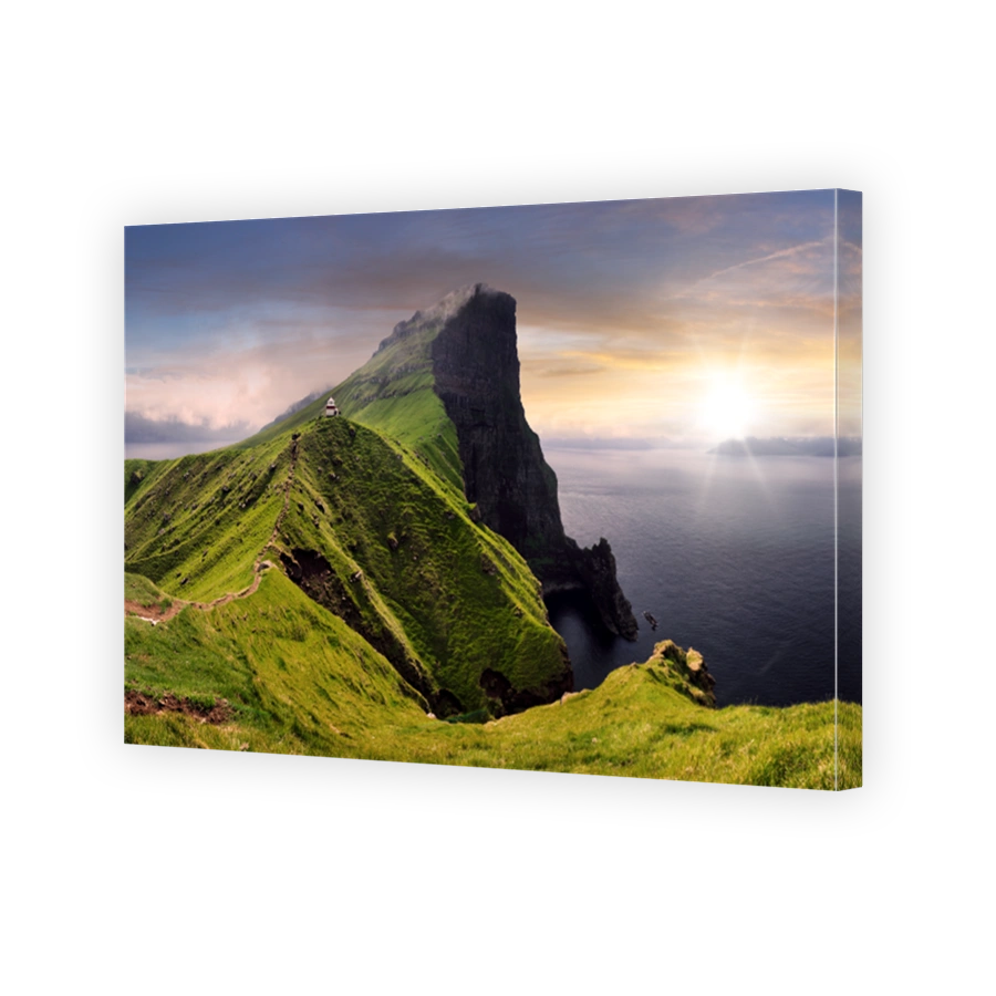 Sunset over green mountain with atlantic ocean, Faroe islands - Kallur lighthouse