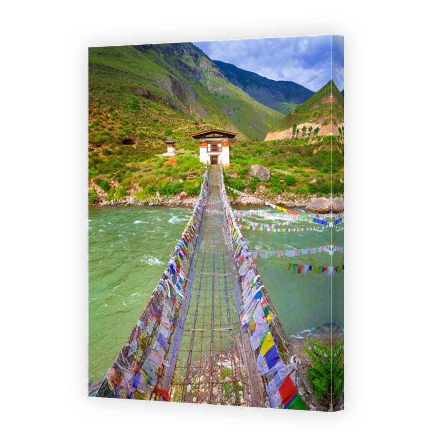 Walking suspension bridge over the river with colorful prayer flags in Bhutan