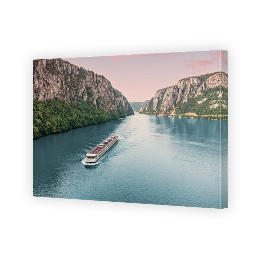 Aerial view of a cruise ship traveling through the Danube River's Iron Gate between Serbia and Romania