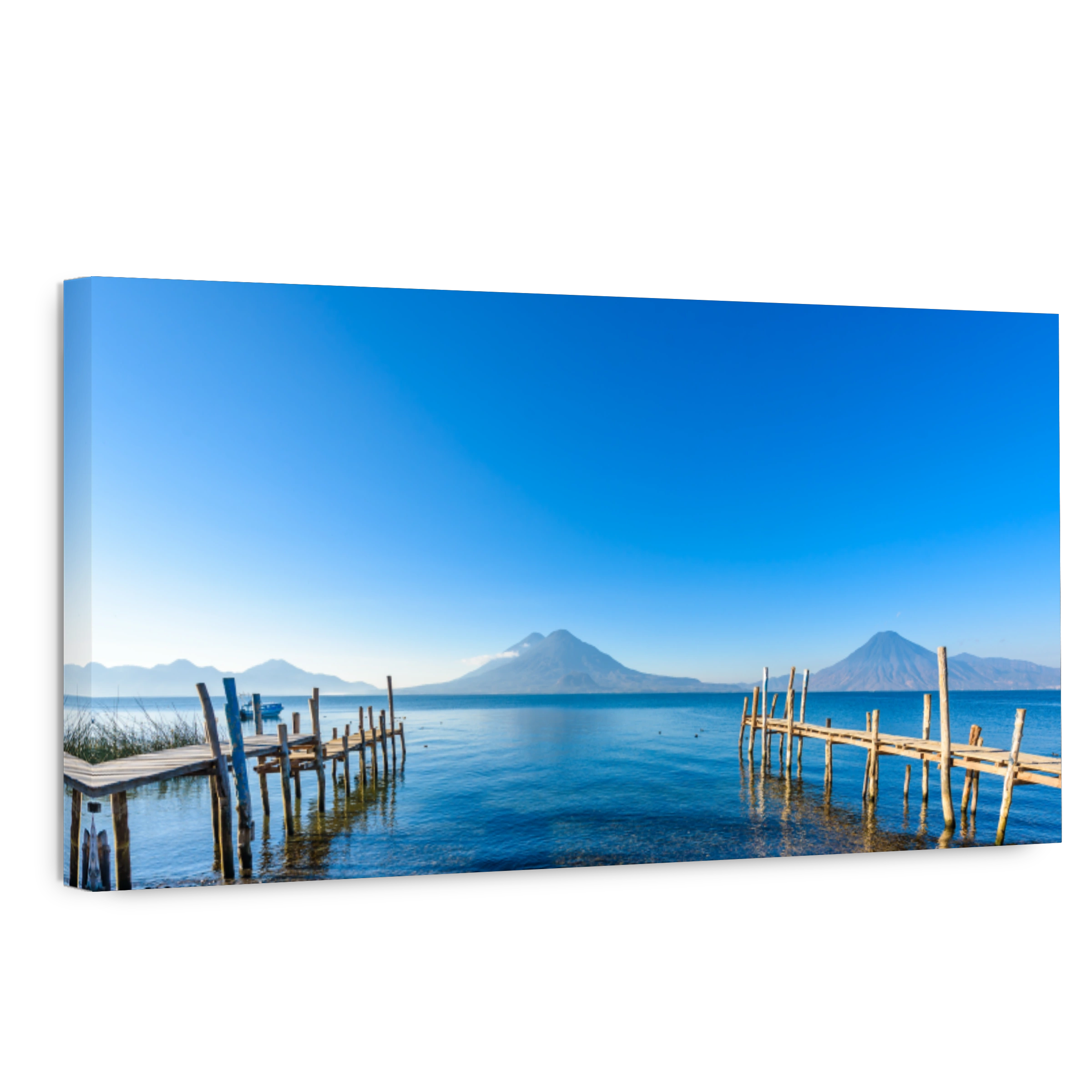 Wooden pier at Lake Atitlan on the beach in Panajachel, Guatemala. With beautiful landscape scenery of volcanoes Toliman, Atitlan and San Pedro in the background. Volcano Highland in Central America.