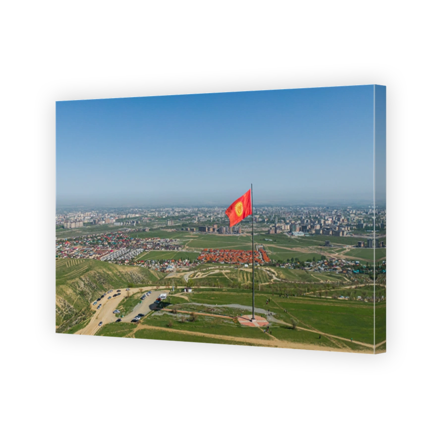Aerial view of Bishkek city from the mountains. Flagpole with Kyrgyzstan flag