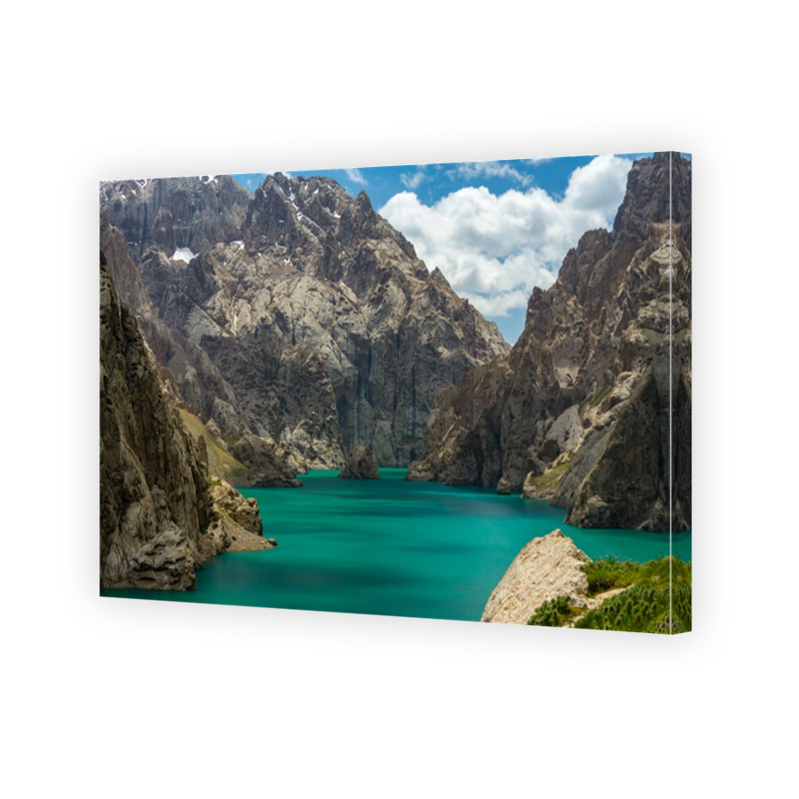 Kel-Suu Lake, a tourist spot on China's border, is surrounded by rocky cliffs, turquoise water of the lake, cloudy sky.