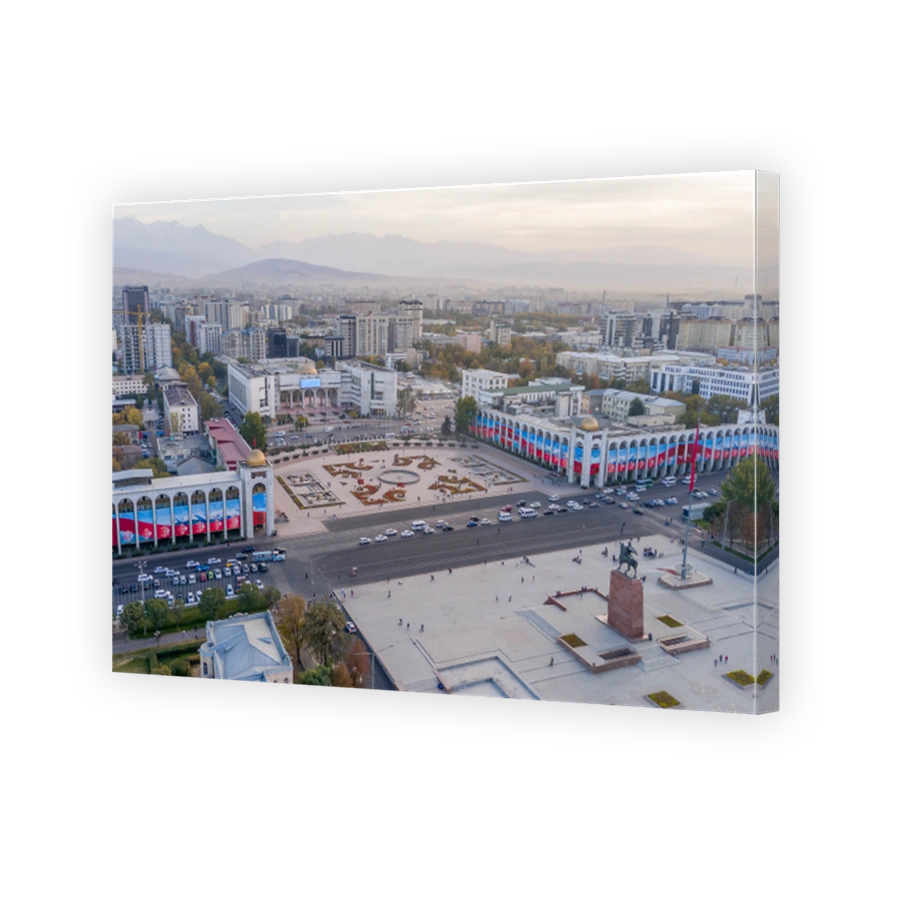 Aerial perspective of Ala-Too Square in Bishkek, where the equestrian Manas statue meets government colonnades and distant Ala-Too peaks