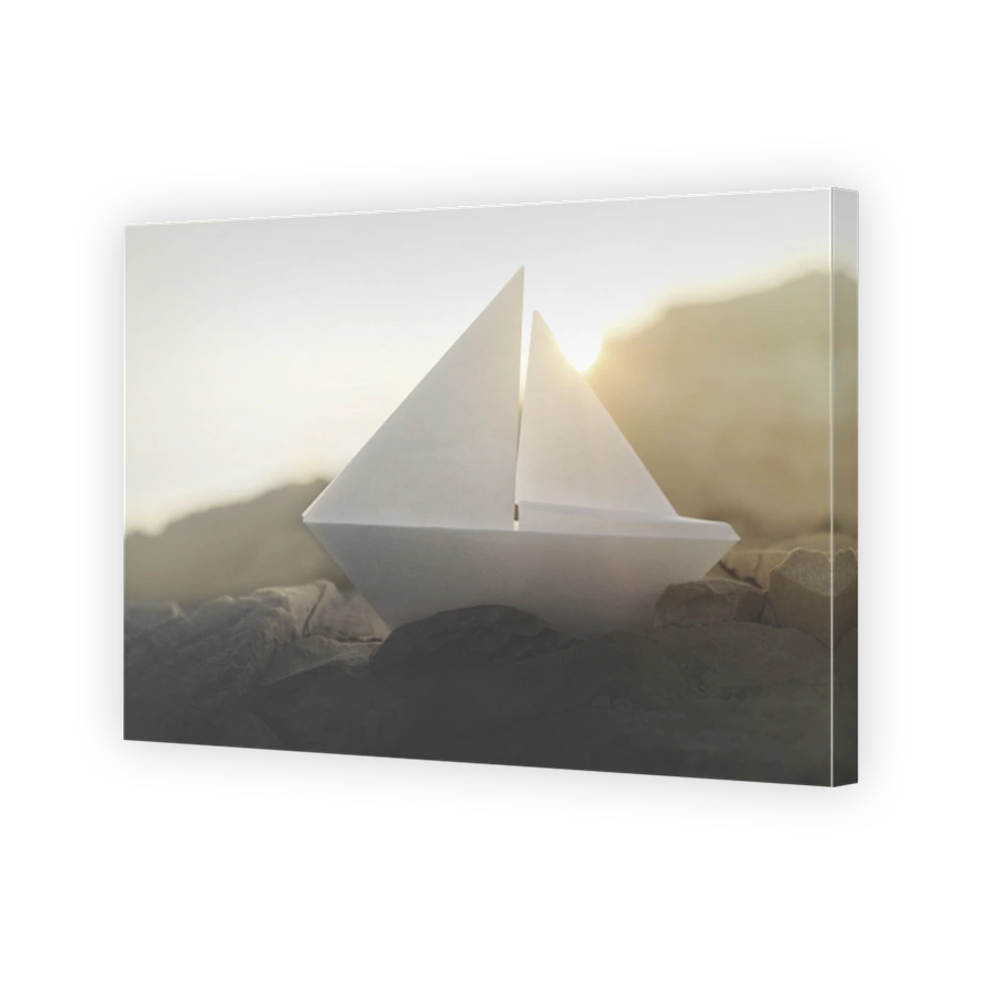 origamo boat sails on the rocks illuminated by the sun
